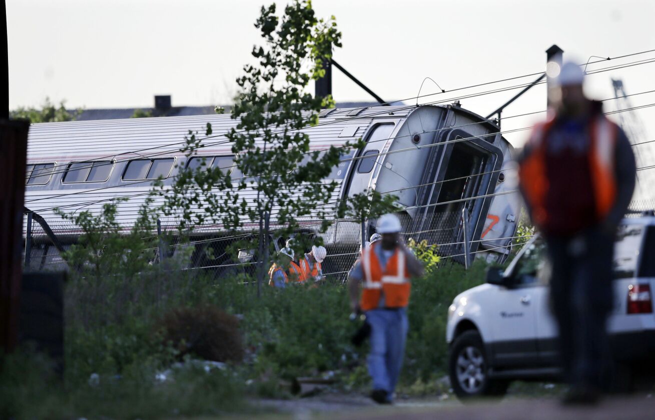Emergency personnel walk near the scene of a deadly train wreck, Wednesday, May 13, 2015, in Philadelphia. | Mel Evans) / AP